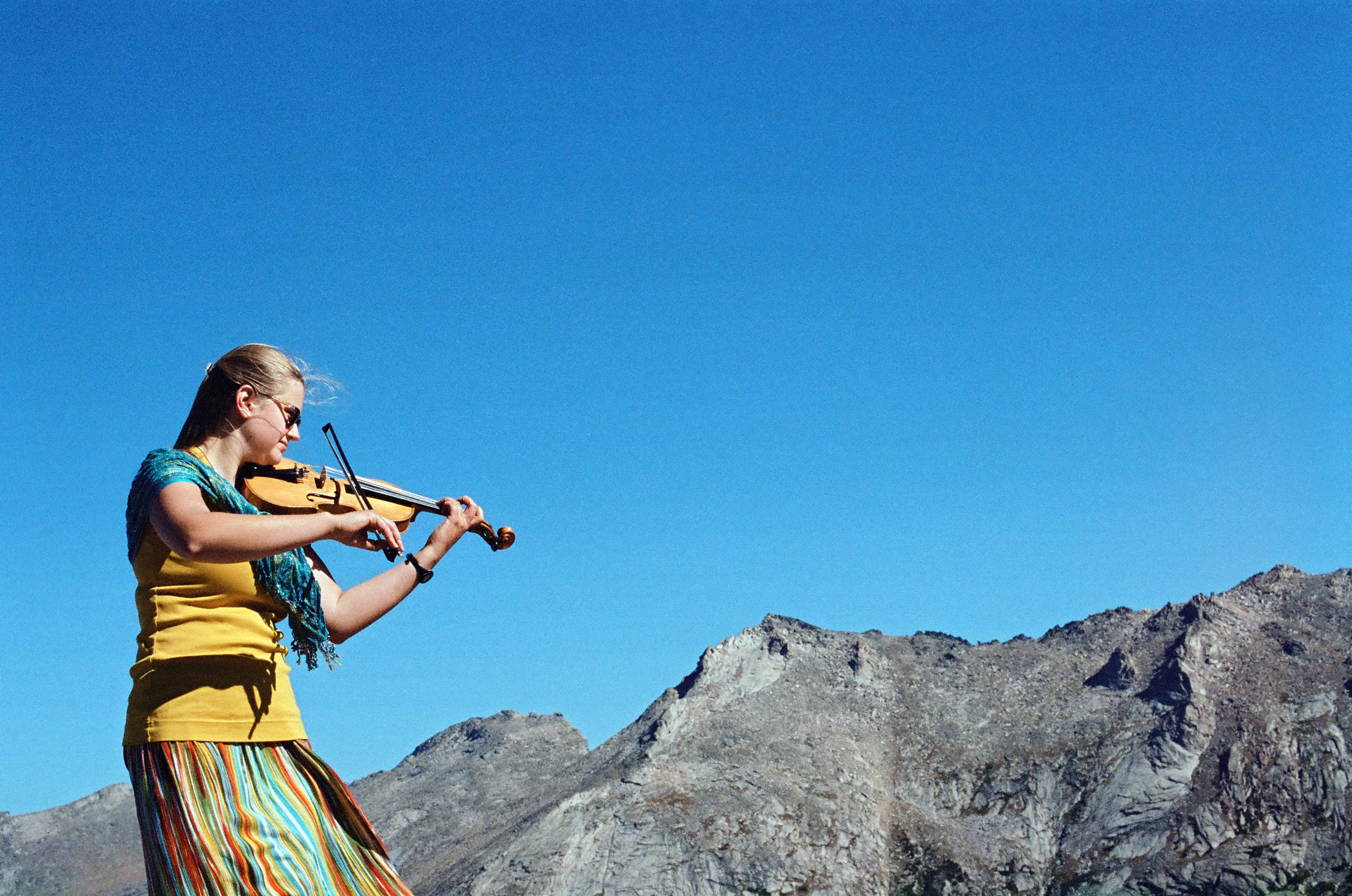 Wyoming Catholic College senior Margaret Serchen plays Bach on her violin atop a mountain in the Wind River range in Wyoming. Credit: Photo courtesy of Margaret Serchen