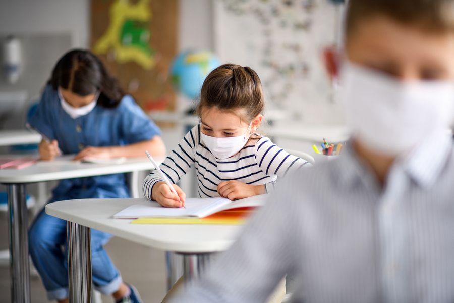 Catholic students wear masks while working in the classroom.