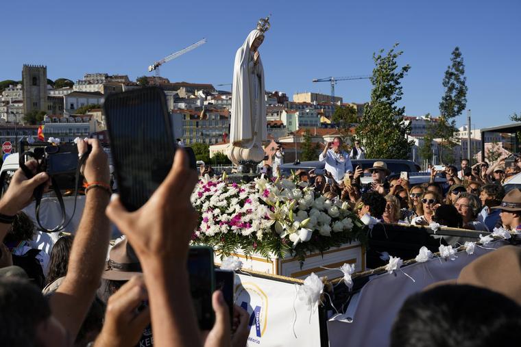 Pilgrims take pictures of a replica of the Our Lady of Fatima statue, from the Marian shrine, after it arrived by boat in Lisbon for the week of the World Youth Day, Monday, July 31, 2023. The international World Youth Day will be held from Aug. 1 to 6, and the presence of Pope Francis is expected to bring hundreds of thousands of young Catholic faithful to Lisbon. 