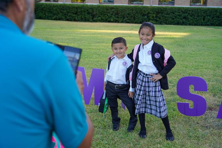 Catholic students smile as a family member snaps a photo on the first day of classes in Dallas on Aug. 14.
