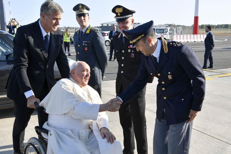 Pope Francis greets airline workers as he boards the papal plane for his four-day trip to Mongolia on Aug. 31, 2023.