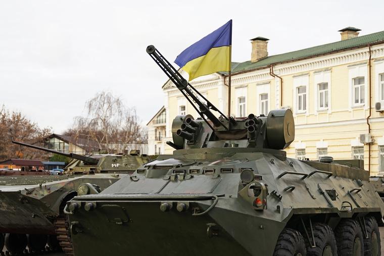 Army troops transporter and tank with Ukrainian flag. 