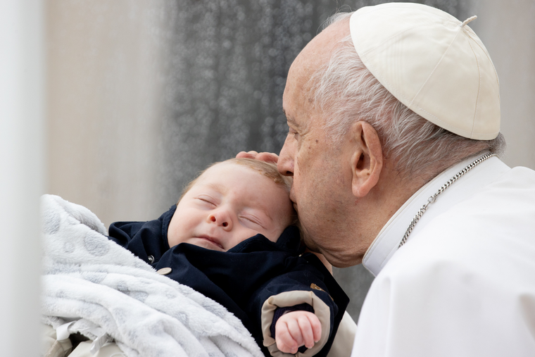 Pope Francis kisses a baby during his weekly General Audience May 10, 2023.